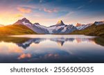 A high snow-capped rocky massif is reflected in Lake Bachalpsee at sunset. Location place Bernese Alps, Grindelwald valley, Europe. Photo wallpaper. Popular attraction. Discovery the beauty of earth.