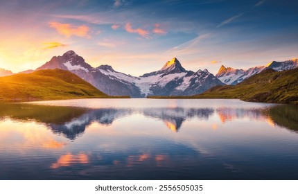 A high snow-capped rocky massif is reflected in Lake Bachalpsee at sunset. Location place Bernese Alps, Grindelwald valley, Europe. Photo wallpaper. Popular attraction. Discovery the beauty of earth. - Powered by Shutterstock