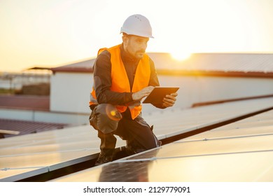 High solar energy usage. A handyman using tablet to test solar panels. - Shutterstock ID 2129779091