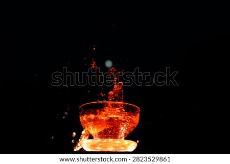 High speed splash compositions of red liquid capture a stunning full moon in the dark night sly.