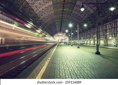 High speed train departs from the station at night time.