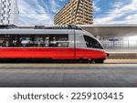 High speed train on the train station at sunset in Vienna, Austria. Beautiful red modern intercity passenger train on the railway platform, buildings. Side view. Railroad. Commercial transportation