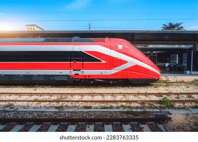 High speed train on the train station at sunny day Venice, Italy. Beautiful red modern intercity passenger train on the railway platform. Railroad in Europe. Railway station. Passenger transportation