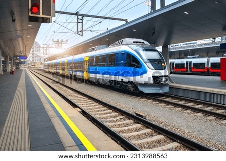 High speed train on the train station at sunset in Vienna, Austria. Beautiful blue modern intercity passenger train on the railway platform. Railroad in Europe. Commercial transportation. Railway Foto stock © 