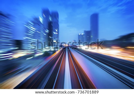 High speed train passing in between Kuala Lumpur City during dusk hour. Focus on the rail road.