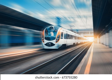 High Speed Train At The Railway Station At Sunset In Europe. Modern Intercity Train On Railway Platform. Urban Scene With Beautiful Passenger Train On Railroad And Buildings. Railway Landscape