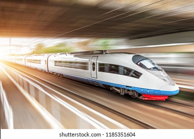 High Speed Train Rides At High Speed At The Railway Station In The City, Through A Tunnel Under A Bridge