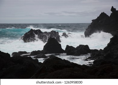 high storm waves splashing onto the sharp lava stones on the coast - Powered by Shutterstock