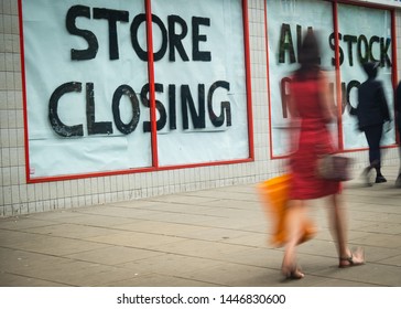 High Street 'Store Closing' sign with motion blurred shopper walking past