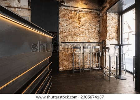 High tables and matching stools in a pub with exposed brick walls