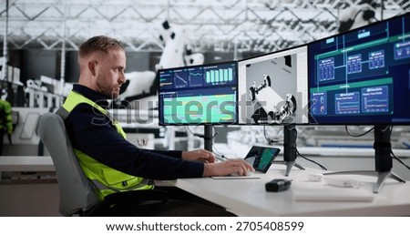 High Tech Assembly Line: Young Engineer Monitoring Vehicle Production Process