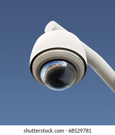 High Tech Overhead Security Camera With A Gradient Blue Sky.