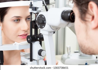 High technology concept health for eyes care - The optician ophthalmology doctor optometrist in the eyes clinic using a binocular slit-lamp to a young woman for an eye control