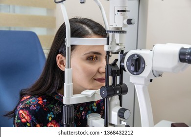 High technology concept health for eyes care - The optician ophthalmology doctor optometrist in the eyes clinic using a binocular slit-lamp to a young woman for an eye control. 