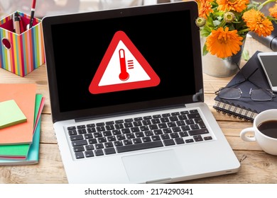 High temperature warning sign on a laptop screen.  Computer overheating concept. Heavy load and hot weather danger. Business office desk background.
