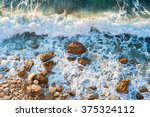 High tide on a rocky beach at sunset