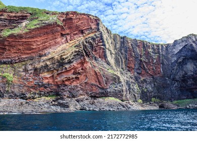 A High, Unique Red Sea Cliff Formed By The Eroded Outer Rim Of An Ancient Super Volcano On A Famous Island In The Japan Sea.