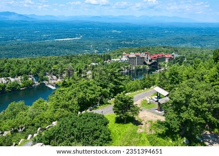 High vantage point view of Mohonk Mountain House in upstate New York with lake and mountains in distance.