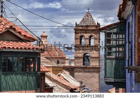 High view of the ancient bell tower of San Francisco church between colonial balconies and rooftops in Potosi, Bolivia. Religious architecture. Southamerica