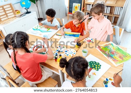 High view over group of different ethnic children enjoy to draw and paint the picture in the classroom in the concept of good activity to generate better creation for kids.