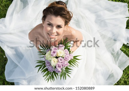 High View Portrait Of Beautiful Happy Bride Sitting On The Grass