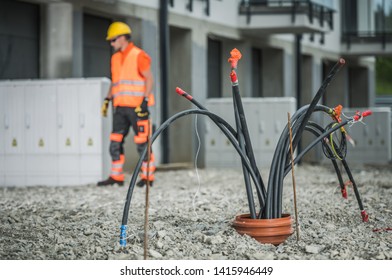 High Voltage Cables Installation. Bunch of Cables Comping From Underground Pipeline. Electric Technician in the Background. - Shutterstock ID 1415946449