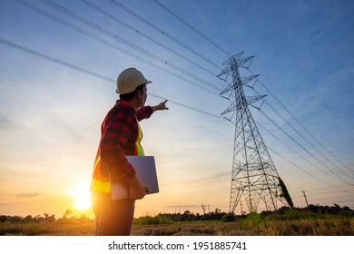 High voltage, construction electrical engineer or technician standing and watching at the worker checking location site near to High voltage tower.