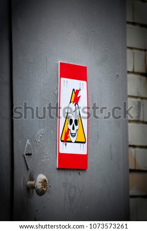 high voltage danger yellow sign on a brick wall building