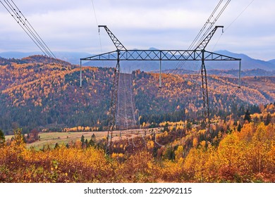 High voltage electric transmission pylon. Electricity transmission pylon against autumn forest on mountain slops in Ukrainian Carpathians. High voltage electric tower. - Shutterstock ID 2229092115