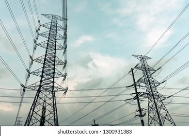 High voltage electricity distribution pole with trees shadow at sunset, electric supply transmission pylon line for energy generator technology industry - Shutterstock ID 1300931383