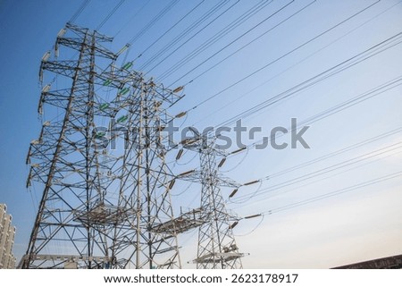High voltage line tower power system under urban blue sky