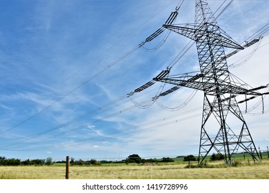 high voltage metal poles with wires
  outdoors under the blue sky
