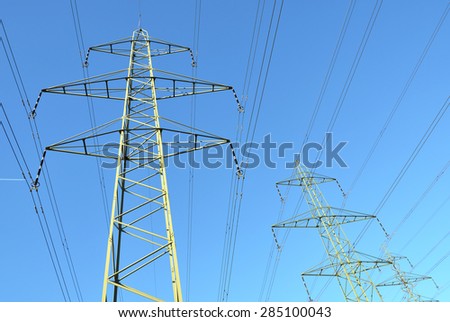 High voltage power lines against blue sky