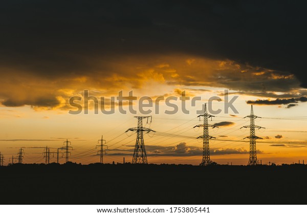 high voltage power lines in a wheat field at\
sunset background\
