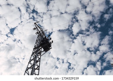 High Voltage Power Pole Seen From Below On A Cloudy Day. Relationship Between Human Action, The Natural Environment And The Climate.