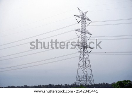 High voltage power source tower or SUTET with a cloudy morning sky background. This is a structure used in the transmission and distribution of electric power to deliver electricity to distant places.