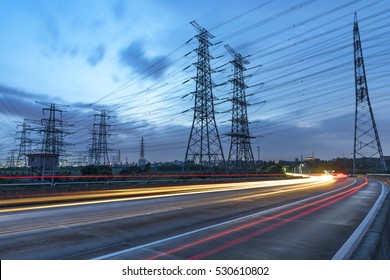 High Voltage, High Speed Road Car Track In The Background Of High Voltage Towers