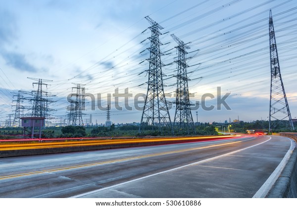 High voltage, high speed road car track in\
the background of high voltage\
towers
