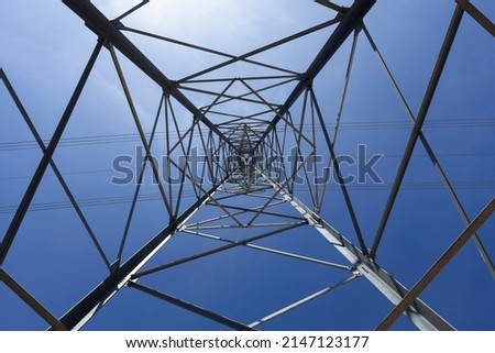 high voltage steel power pole structure against the blue sky with abstract geometric shapes. electric transmission tower. abstract Infrastructure