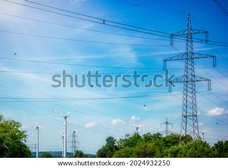 High voltage tower and wind turbine construction, beautiful landscape, blue sky, clean renewable green energy for sustainable development to prevent climate change and global warming to protect earth
