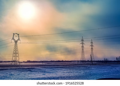 A high voltage transmission line corridor set against ice fog in the setting sun.