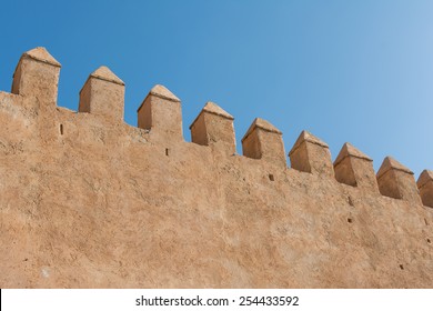 High wall made with clay under blue sky