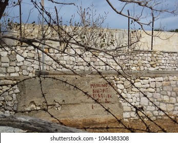 High Wall Made From Stone Built By Political Convicts Judged On Forced Labor And Rusty Metal Wire