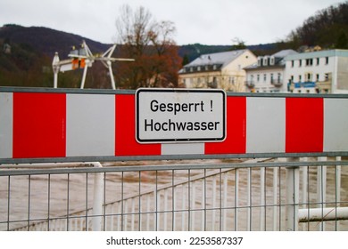 High water warning street sign in germany. Spa town embankment under water. High water warning sign, red and white flood barrier.  - Shutterstock ID 2253587337