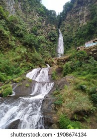 high waterfall with cliffs full of greenery