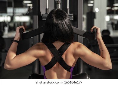 High. Young muscular caucasian woman practicing in gym with equipment. Athletic female model doing speed exercises, training her hands and chest, upper body. Wellness, healthy lifestyle, bodybuilding.