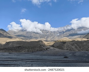 From the high-altitude vantage point, the mountains rise majestically, their peaks shrouded in a veil of misty clouds. The sky and earth blend seamlessly, creating a serene and ethereal landscape. - Powered by Shutterstock