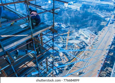 High-altitude work. Construction of the bridge. Workers on scaffolding.