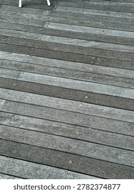 High-angle background texture of weathered grey wooden planks secured with visible metal screws.