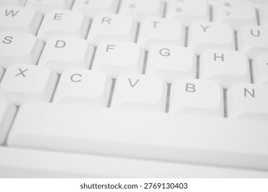 High-angle close-up of a white computer keyboard. Minimalist bright shot showing clean alphanumeric keys and spacebar for technology and office concepts